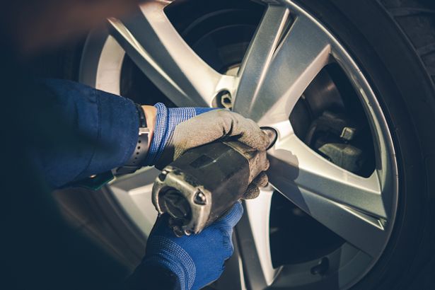 A mechanic doing a tire replacement on a car
